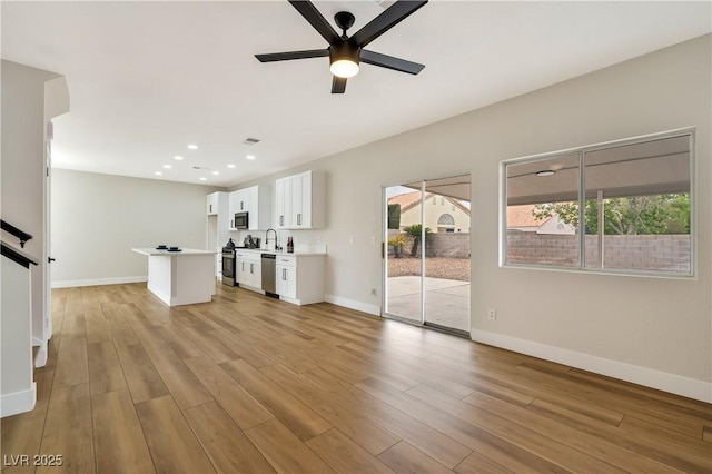 6388 Canyon Dawn Ave, Las Vegas, NV 89108 - unfurnished living room with a ceiling fan, baseboards, light wood finished floors, recessed lighting, and a sink