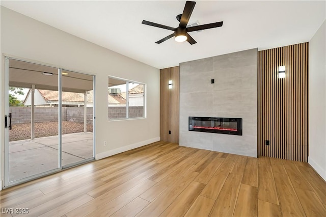 6388 Canyon Dawn Ave, Las Vegas, NV 89108 - unfurnished living room with wood finished floors, a ceiling fan, a tiled fireplace, baseboards, and heating unit