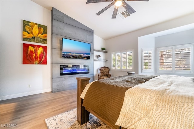 2144 Paganini Ave, Henderson, NV 89052 - bedroom featuring wood finished floors, baseboards, a fireplace, a ceiling fan, and high vaulted ceiling