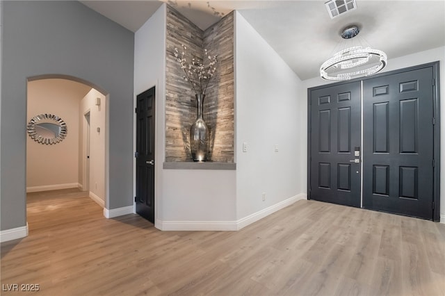 2144 Paganini Ave, Henderson, NV 89052 - entrance foyer featuring arched walkways, baseboards, a chandelier, wood finished floors, and high vaulted ceiling
