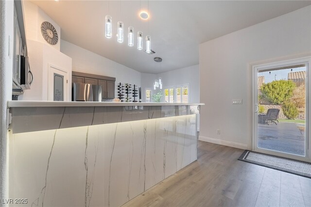 2144 Paganini Ave, Henderson, NV 89052 - kitchen with appliances with stainless steel finishes, light wood-type flooring, pendant lighting, baseboards, and lofted ceiling
