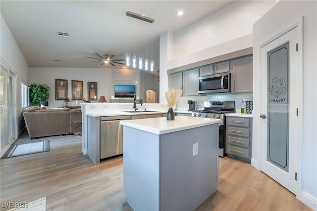2144 Paganini Ave, Henderson, NV 89052 - kitchen with appliances with stainless steel finishes, gray cabinets, open floor plan, light countertops, and a high ceiling