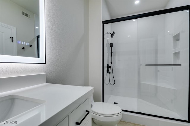 9050 W Warm Springs Rd Unit 1117, Las Vegas, NV 89148 - bathroom featuring toilet, a shower stall, vanity, and a textured wall
