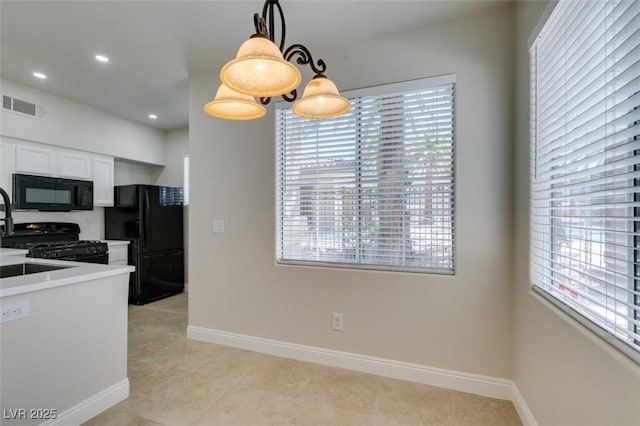 9050 W Warm Springs Rd Unit 1117, Las Vegas, NV 89148 - kitchen with black appliances, plenty of natural light, hanging light fixtures, white cabinetry, and recessed lighting