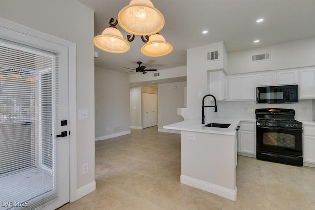 9050 W Warm Springs Rd Unit 1117, Las Vegas, NV 89148 - kitchen featuring black appliances, a peninsula, white cabinets, a sink, and light countertops