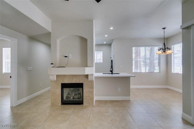 9050 W Warm Springs Rd Unit 1117, Las Vegas, NV 89148 - unfurnished living room featuring recessed lighting, baseboards, light tile patterned floors, a fireplace, and a chandelier