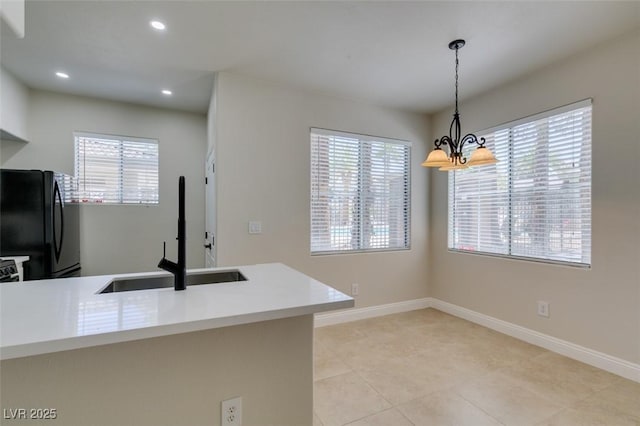 9050 W Warm Springs Rd Unit 1117, Las Vegas, NV 89148 - kitchen featuring freestanding refrigerator, a sink, a chandelier, healthy amount of natural light, and recessed lighting