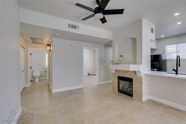 9050 W Warm Springs Rd Unit 1117, Las Vegas, NV 89148 - unfurnished living room featuring a sink, ceiling fan, light tile patterned flooring, a fireplace, and recessed lighting