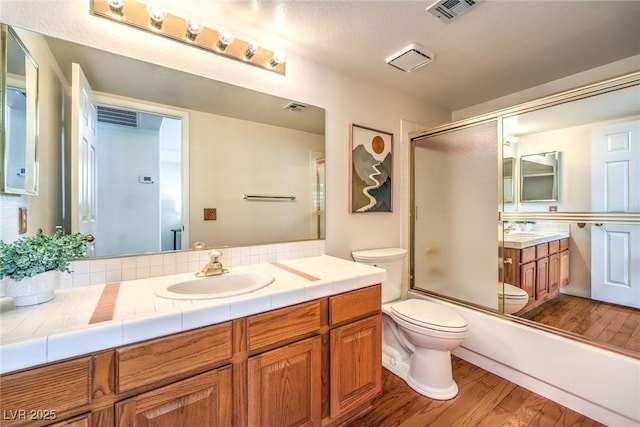 8428 Apple Hill Ct, Las Vegas, NV 89128 - bathroom with toilet, vanity, wood finished floors, and bath / shower combo with glass door