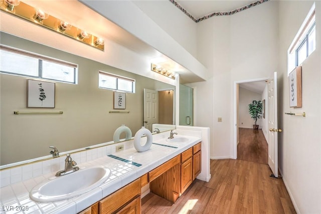 8428 Apple Hill Ct, Las Vegas, NV 89128 - full bath featuring wood finished floors, double vanity, plenty of natural light, baseboards, and a towering ceiling
