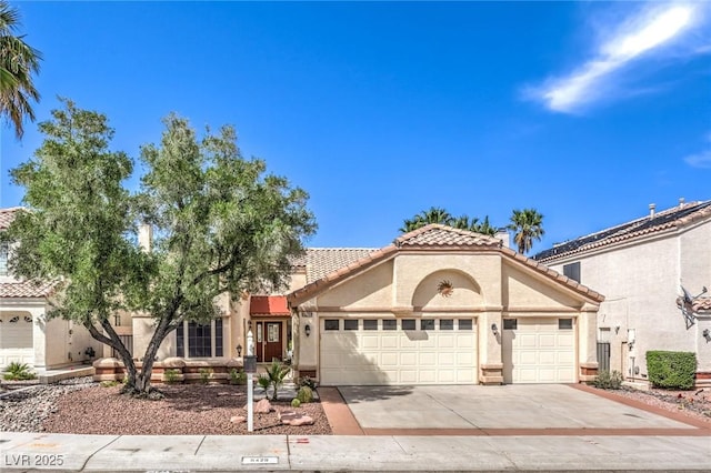 8428 Apple Hill Ct, Las Vegas, NV 89128 - mediterranean / spanish-style house featuring stucco siding, an attached garage, a tiled roof, and concrete driveway