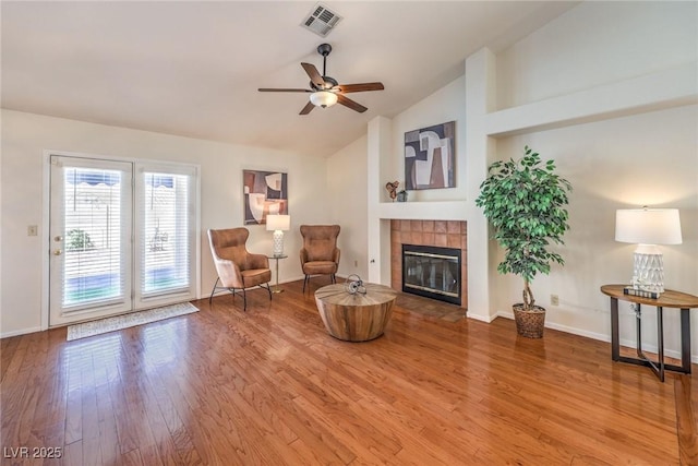 8428 Apple Hill Ct, Las Vegas, NV 89128 - living area featuring wood finished floors, a tiled fireplace, vaulted ceiling, ceiling fan, and baseboards