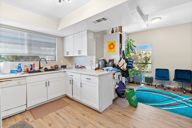 2643 Red Rock St Unit 201, Las Vegas, NV 89146 - kitchen featuring white dishwasher, light wood-type flooring, a sink, light countertops, and white cabinetry