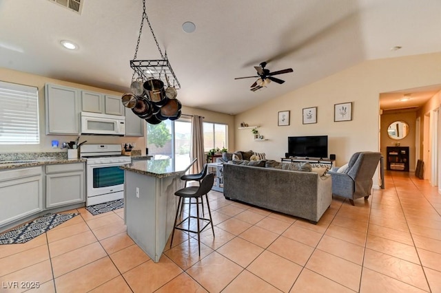 3823 Aspen Creek Ave, North Las Vegas, NV 89031 - kitchen featuring white appliances, lofted ceiling, a ceiling fan, light tile patterned floors, and a center island