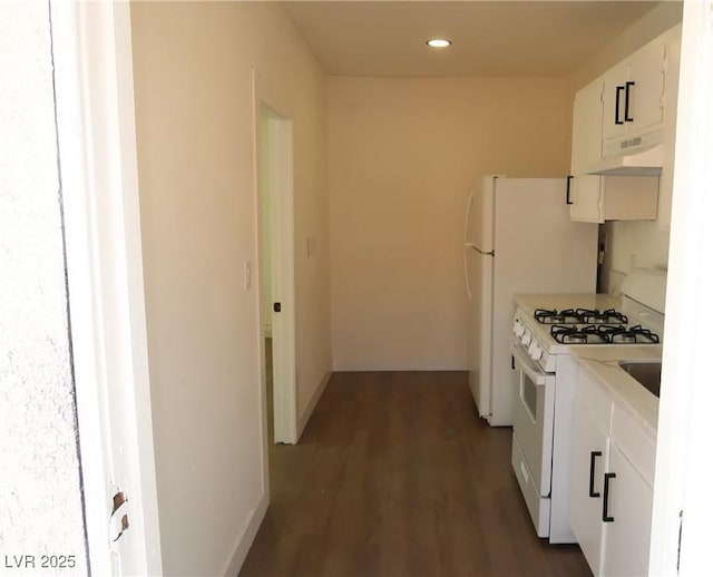 404 Vassar Ln, Las Vegas, NV 89107 - kitchen featuring white appliances, white cabinets, under cabinet range hood, light countertops, and dark wood-style flooring