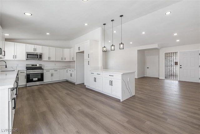 404 Vassar Ln, Las Vegas, NV 89107 - kitchen featuring appliances with stainless steel finishes, a sink, open floor plan, dark wood-style floors, and recessed lighting