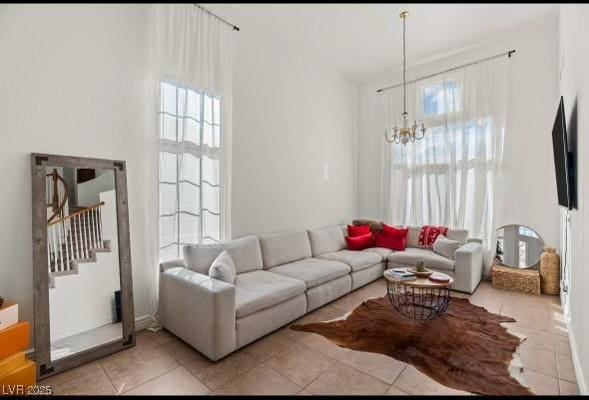 59 Desert Dawn Ln, Henderson, NV 89074 - living room featuring a chandelier, plenty of natural light, light tile patterned floors, stairway, and a towering ceiling