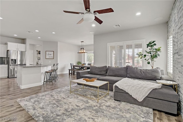 5742 Shadow Bend Dr, Las Vegas, NV 89135 - living room with ceiling fan, recessed lighting, light wood-type flooring, and a chandelier