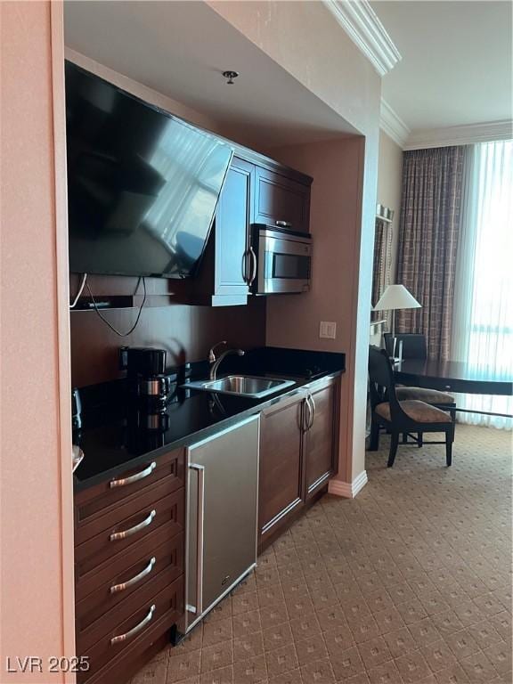 125 E Harmon Ave Unit 2918, Las Vegas, NV 89109 - kitchen featuring stainless steel microwave, a sink, dark countertops, ornamental molding, and baseboards