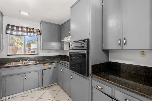 5101 Churchill Ave, Las Vegas, NV 89107 - kitchen with black oven, a sink, gray cabinetry, light tile patterned floors, and under cabinet range hood