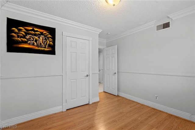 5101 Churchill Ave, Las Vegas, NV 89107 - unfurnished bedroom with a textured ceiling, light wood finished floors, ornamental molding, and baseboards