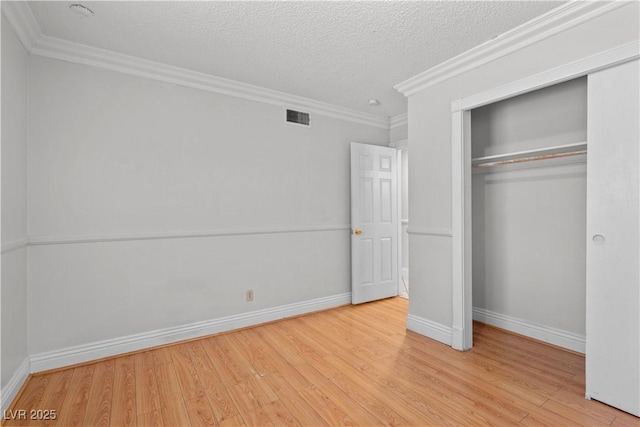 5101 Churchill Ave, Las Vegas, NV 89107 - unfurnished bedroom with light wood finished floors, a closet, a textured ceiling, baseboards, and crown molding