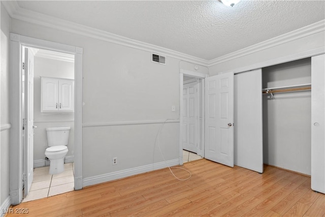 5101 Churchill Ave, Las Vegas, NV 89107 - unfurnished bedroom featuring light wood-style floors, ensuite bathroom, crown molding, a textured ceiling, and a closet