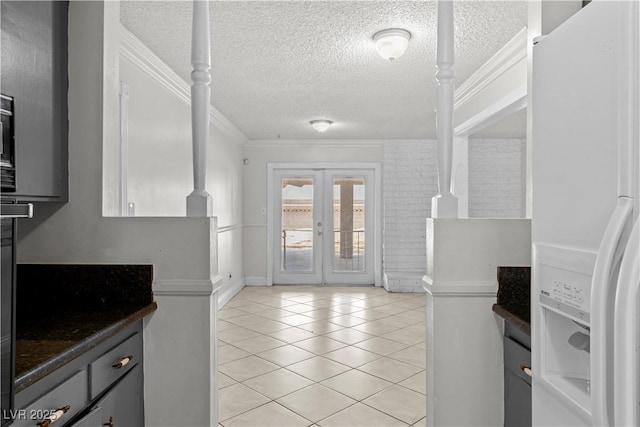 5101 Churchill Ave, Las Vegas, NV 89107 - kitchen with white fridge with ice dispenser, crown molding, a textured ceiling, dark countertops, and light tile patterned floors