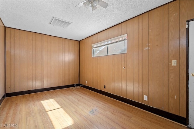5101 Churchill Ave, Las Vegas, NV 89107 - unfurnished room featuring wood finished floors, a ceiling fan, wood walls, and a textured ceiling