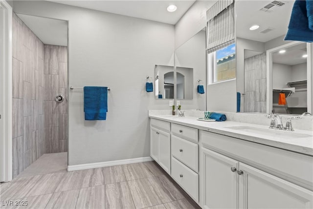 10416 Skye Arroyo Ave, Las Vegas, NV 89166 - bathroom featuring double vanity, walk in shower, baseboards, recessed lighting, and a walk in closet