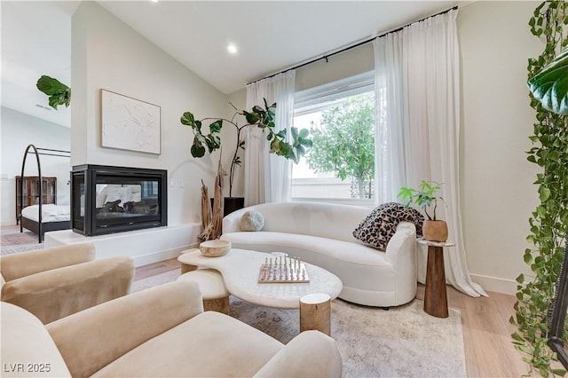 2345 Villandry Ct, Henderson, NV 89074 - living area with lofted ceiling, wood finished floors, a multi sided fireplace, and recessed lighting