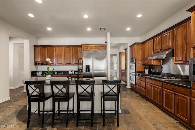 48 Panorama Crest Ave, Las Vegas, NV 89135 - kitchen featuring appliances with stainless steel finishes, under cabinet range hood, a kitchen bar, decorative backsplash, and recessed lighting