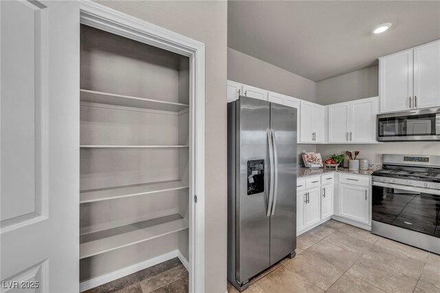 9876 Magnus Ct, Las Vegas, NV 89178 - kitchen with stainless steel appliances, white cabinetry, light stone counters, and recessed lighting