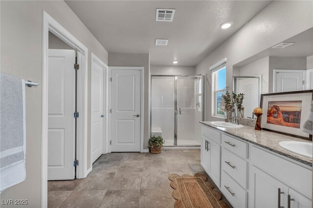 9876 Magnus Ct, Las Vegas, NV 89178 - bathroom with a shower stall, double vanity, and recessed lighting