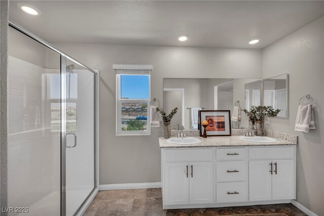 9876 Magnus Ct, Las Vegas, NV 89178 - bathroom featuring double vanity, baseboards, and a stall shower