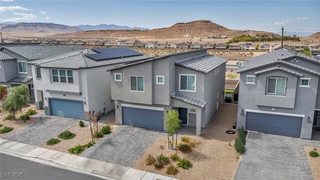 9876 Magnus Ct, Las Vegas, NV 89178 - view of front of home featuring an attached garage, stucco siding, a mountain view, and a residential view