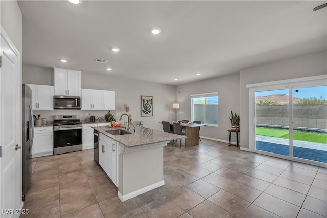 9876 Magnus Ct, Las Vegas, NV 89178 - kitchen featuring stainless steel appliances, a sink, recessed lighting, white cabinets, and light stone counters