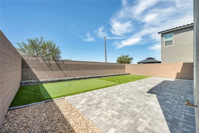 9876 Magnus Ct, Las Vegas, NV 89178 - fenced backyard featuring a putting green and a patio