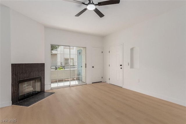 3318 N Decatur Blvd Unit 1020, Las Vegas, NV 89130 - unfurnished living room featuring wood finished floors, a ceiling fan, a tiled fireplace, and baseboards