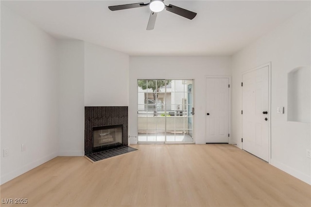 3318 N Decatur Blvd Unit 1020, Las Vegas, NV 89130 - unfurnished living room featuring wood finished floors, a tile fireplace, ceiling fan, and baseboards