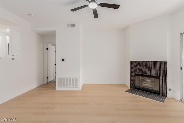 3318 N Decatur Blvd Unit 1020, Las Vegas, NV 89130 - unfurnished living room with light wood-style flooring, a ceiling fan, and a tiled fireplace