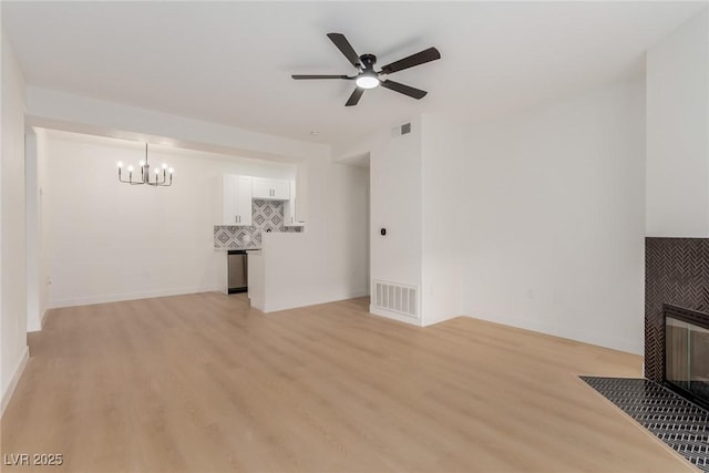 3318 N Decatur Blvd Unit 1020, Las Vegas, NV 89130 - unfurnished living room with a chandelier, light wood-type flooring, a tiled fireplace, and a ceiling fan