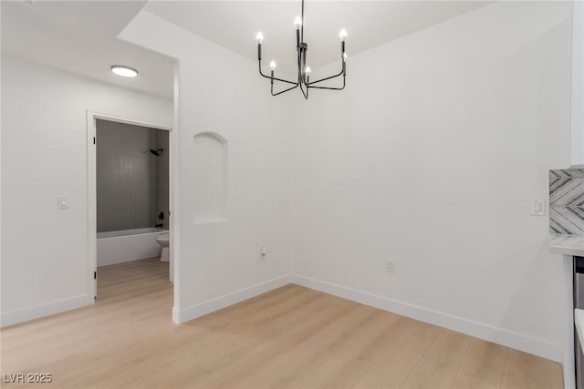 3318 N Decatur Blvd Unit 1020, Las Vegas, NV 89130 - unfurnished dining area featuring a chandelier, light wood finished floors, and baseboards