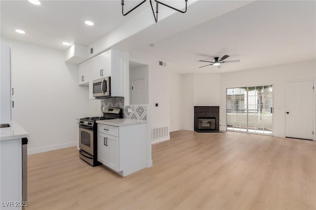 3318 N Decatur Blvd Unit 1020, Las Vegas, NV 89130 - kitchen featuring stainless steel appliances, light wood finished floors, light countertops, white cabinetry, and baseboards