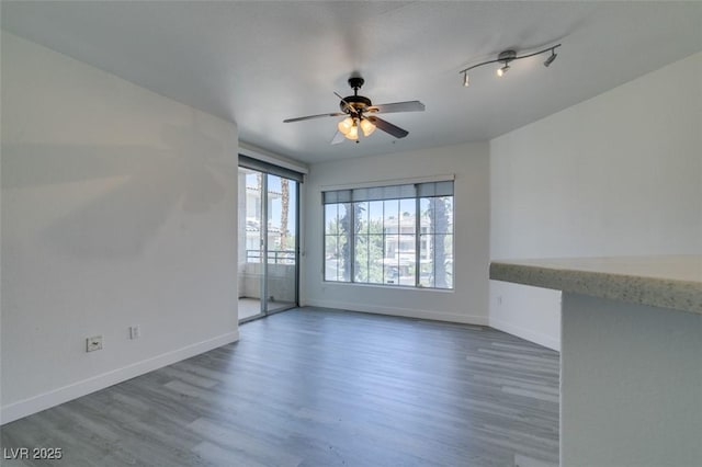 7151 S Durango Dr Unit 211, Las Vegas, NV 89113 - empty room featuring baseboards, wood finished floors, and a ceiling fan