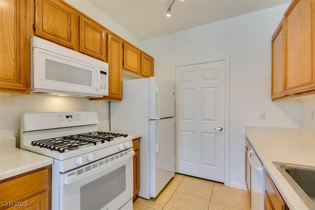 7151 S Durango Dr Unit 211, Las Vegas, NV 89113 - kitchen with white appliances, light tile patterned flooring, light countertops, and brown cabinetry