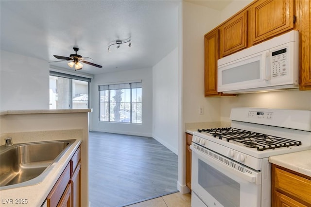 7151 S Durango Dr Unit 211, Las Vegas, NV 89113 - kitchen featuring white appliances, brown cabinets, a sink, light countertops, and ceiling fan