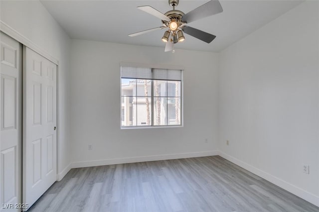 7151 S Durango Dr Unit 211, Las Vegas, NV 89113 - unfurnished bedroom featuring light wood-style flooring, a closet, baseboards, and ceiling fan