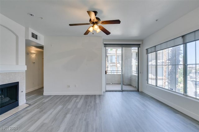 7151 S Durango Dr Unit 211, Las Vegas, NV 89113 - unfurnished living room featuring a ceiling fan, wood finished floors, baseboards, and a fireplace