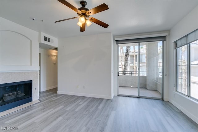 7151 S Durango Dr Unit 211, Las Vegas, NV 89113 - unfurnished living room featuring wood finished floors, a ceiling fan, baseboards, and a tile fireplace